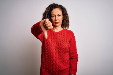 Orta yaşlı esmer kadın, izole edilmiş beyaz arka planda dikilen sıradan bir kazak giyiyor mutsuz ve kızgın görünüyor, reddedilmiş ve olumsuz bir hareket sergiliyor. Kötü ifade.