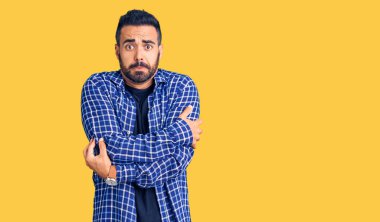 Latin kökenli genç bir adam günlük kıyafetler giyiyor. Kış soğuğu için titriyor ve donuyor. Yüzünde üzgün ve şok ifadesi var. 