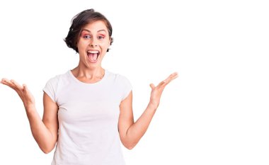 Kısa saçlı güzel bir kadın zaferi mutlu bir gülümsemeyle ve ellerini kaldırarak kutluyor. 