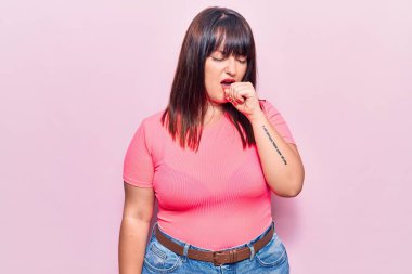 Sıradan kıyafetler giyen, kendini kötü hisseden ve soğuk algınlığı veya bronşitin belirtisi olarak öksüren genç ve iri yarı bir kadın. sağlık hizmeti kavramı. 