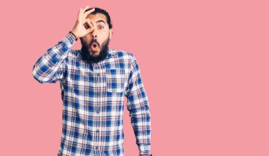 Gündelik giysiler giyen genç Arap adam şaşırmış yüz ifadesiyle şok olmuş, parmaklarından bakan gözler. İnançsız ifade. 