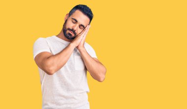 Gündelik kıyafetler giyen genç İspanyol adam uyur. Yorgun düşler kurar, ellerle poz verir, gözleri kapalı gülümserdi.. 