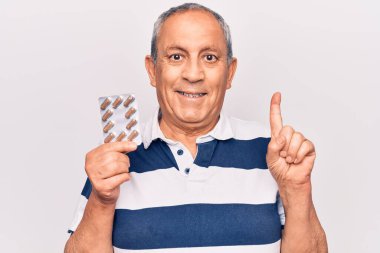 Elinde haplarla gülümseyen yaşlı adam bir fikir ya da soruyla gülümsüyor. 