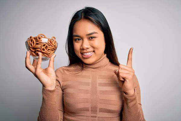 Genç Asyalı Kız Elinde Fırında Alman Krakerleriyle Izole Edilmiş Beyaz — Stok fotoğraf