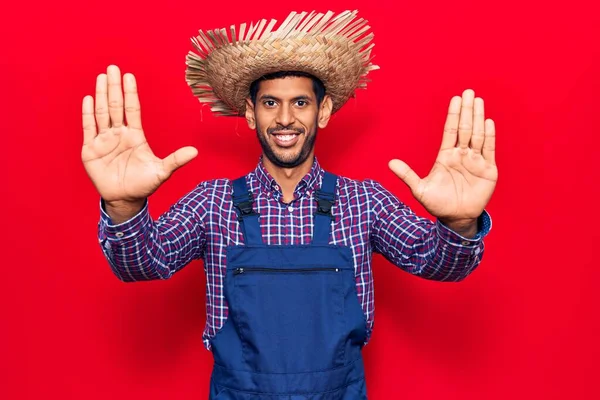 Çiftçi Şapkası Önlüğü Takan Genç Latin Adam Numarayı Gösterip Işaret — Stok fotoğraf