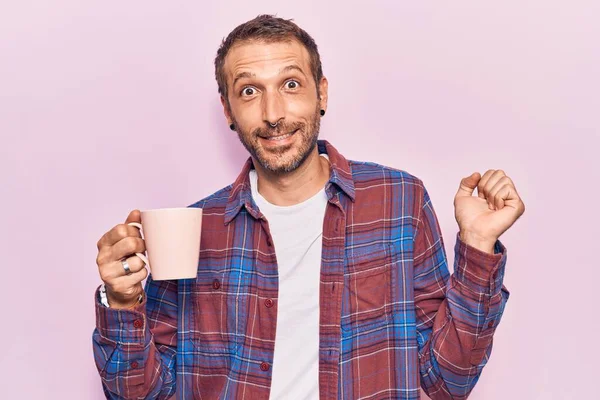 Mladý Pohledný Muž Drží Kávu Křičí Hrdý Slaví Vítězství Úspěch — Stock fotografie