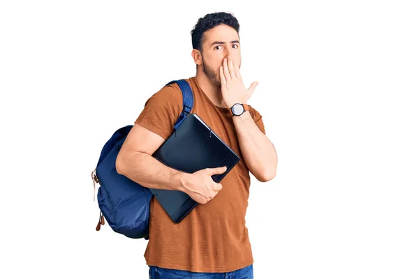 Joven Hombre Hispano Con Mochila Estudiante Sosteniendo Aglutinante Cubriendo Boca —  Fotos de Stock