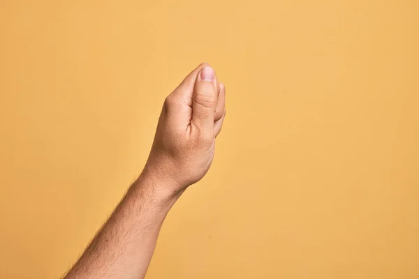 在孤立的黄色背景上伸出无名指的高加索年轻人的手 手握着空白的大拇指 手握商务和广告 — 图库照片