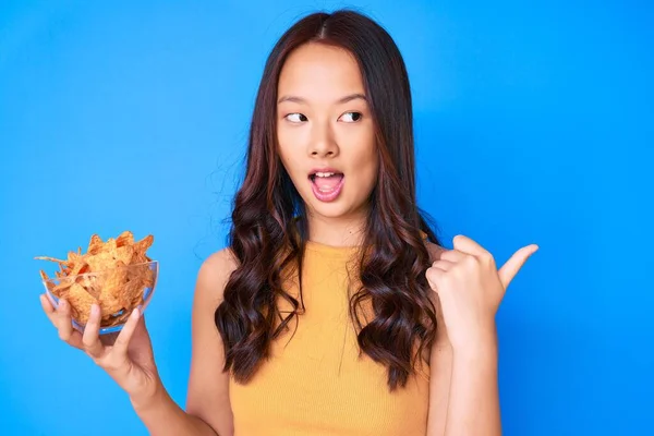 Jovem Menina Chinesa Bonita Segurando Nachos Batatas Fritas Apontando Polegar — Fotografia de Stock