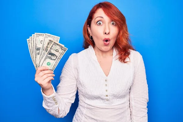 Young Beautiful Redhead Woman Holding Bunch Dollars Banknotes Blue Background — Stock Photo, Image