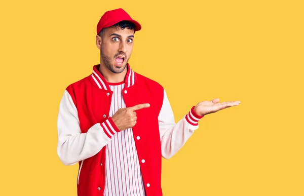 Joven Hispano Vistiendo Uniforme Béisbol Asombrado Sonriendo Cámara Mientras Presenta — Foto de Stock