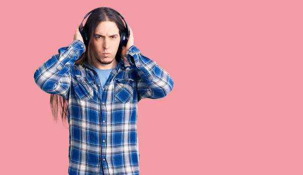 Hombre Adulto Joven Con Cabello Largo Escuchando Música Usando Auriculares —  Fotos de Stock