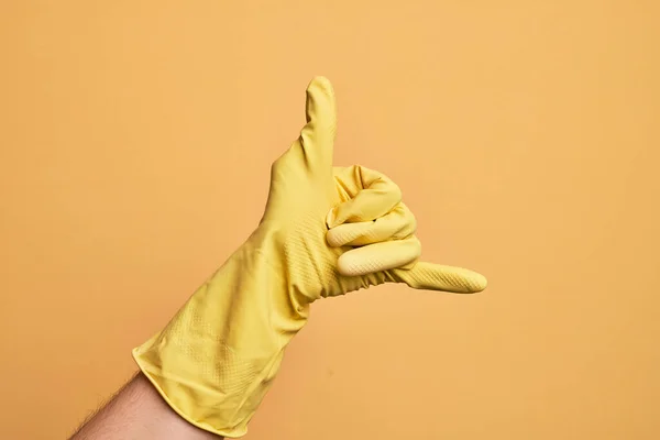 Mão Homem Jovem Caucasiano Com Luva Limpeza Sobre Fundo Amarelo — Fotografia de Stock