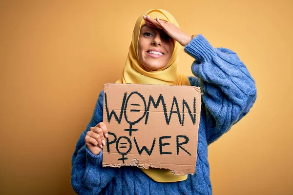 若い美しいアラブ女性の頭の上に手で強調女性のパワーメッセージとイスラムヒジャーブ保持バナーを着て 恥と驚きの顔で 怒っていると不満ショックを受けた 恐怖と過ちへの動揺 — ストック写真