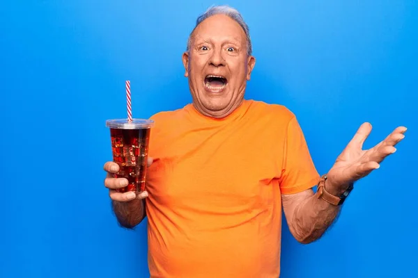 Senior Knappe Grijsharige Man Drinken Cola Verfrissing Drank Blauwe Achtergrond — Stockfoto