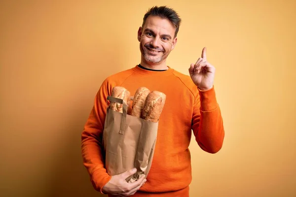 Jovem Homem Bonito Segurando Saco Papel Com Pão Sobre Fundo — Fotografia de Stock