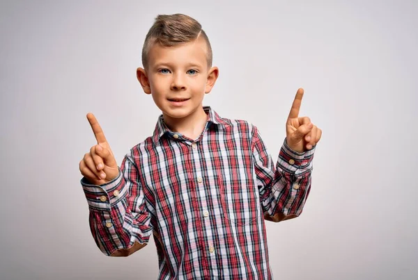 年轻的高加索小孩 蓝眼睛 穿着雅致的衬衫 站在孤立的背景上 带着自信的微笑 用手指指向不同的方向 广告的复制空间 — 图库照片