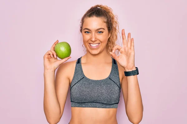 年轻美丽的金发女运动员 蓝眼睛 手握健康的绿色苹果果实 手握手签 很好的象征 — 图库照片