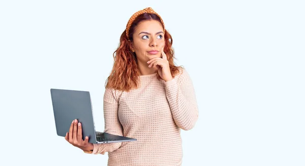 Young Latin Woman Holding Laptop Serious Face Thinking Question Hand — Stock Photo, Image