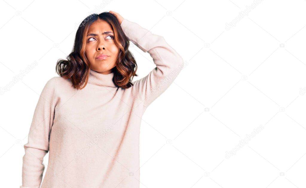 Young beautiful mixed race woman wearing winter turtleneck sweater confuse and wondering about question. uncertain with doubt, thinking with hand on head. pensive concept. 
