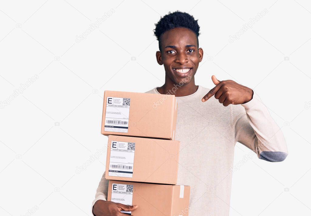 Young african american man holding delivery package pointing finger to one self smiling happy and proud 