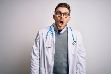 Mavi gözlü genç doktor, tıbbi önlük ve steteskop takıyor. Korkarak, şaşırarak, şaşkınlıkla, şaşkınlıkla, ifadeyle, korkuyla ve heyecanlı yüzüyle..
