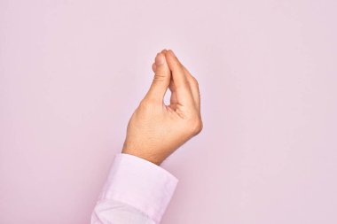 İzole edilmiş pembe arka planda parmaklarını gösteren beyaz bir adamın eli parmaklarıyla İtalyanca jest yapıyor, iletişim hareketi yapıyor.