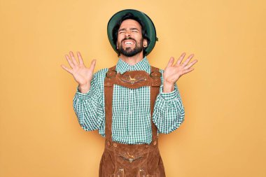 Almanya festivali için geleneksel Alman Ekim Festivali geleneği giyinen genç yakışıklı adam kollarını kaldırarak ve gözlerini kapatarak heyecanla haykırarak çılgın ve çılgın başarısını kutluyor. Kazanan konsept