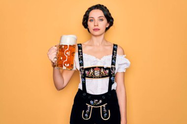 Mavi gözlü güzel Alman kadın geleneksel Ekim Festivali elbisesi giyiyor. Kendine güvenen bir ifadeyle bir kavanoz bira içiyor.