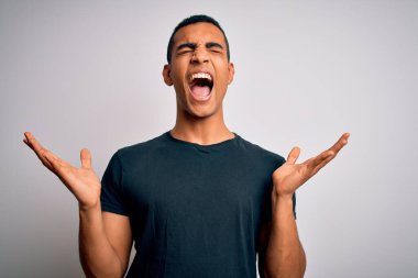 Genç, yakışıklı, Afro-Amerikalı bir adam beyaz arka plan üzerinde dikilmiş kollarını kaldırmış ve gözlerini kapatmış heyecanla haykırarak başarıyı kutluyor. Kazanan konsept