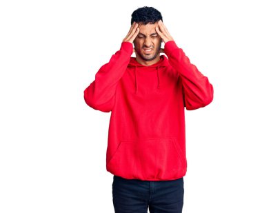 İspanyol asıllı genç adam gündelik giysiler giyiyor. Baş ağrısı çekiyor. Acı ve migren yüzünden çaresiz ve stresli. Eller başının üstünde.. 