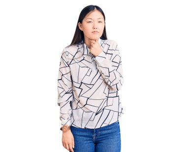 Genç, güzel, Çinli bir kadın. Günlük gömlek giyiyor. Ağrılı boynuna dokunuyor. Grip, mantar ve enfeksiyon yüzünden boğazı ağrıyor. 