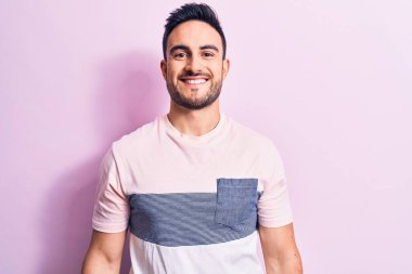 Mayo giyen genç yakışıklı adam ellerinin birarada dua ederek af diliyor kendinden emin bir şekilde gülümsüyor.. 