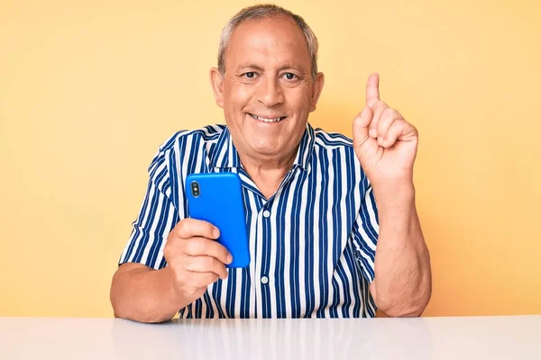 Senior Handsome Man Gray Hair Using Smartphone Sitting Table Surprised — Stock Photo, Image