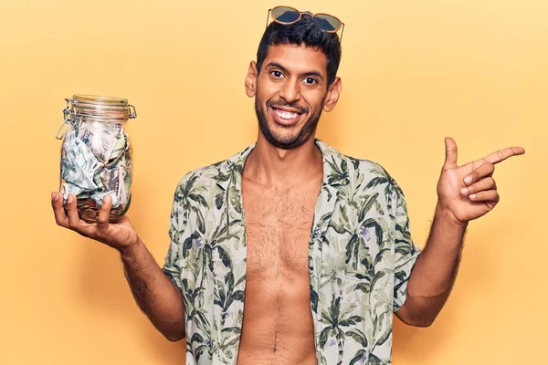 Mladý Latinský Muž Letní Košili Drží Sklenici Úspor Úsměvem Ukazující — Stock fotografie