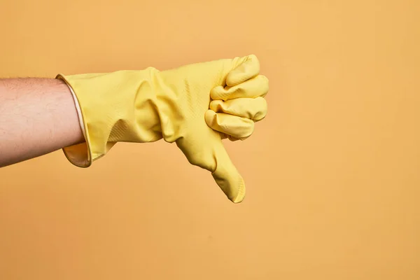 Mão Homem Jovem Caucasiano Com Luva Limpeza Sobre Fundo Amarelo — Fotografia de Stock