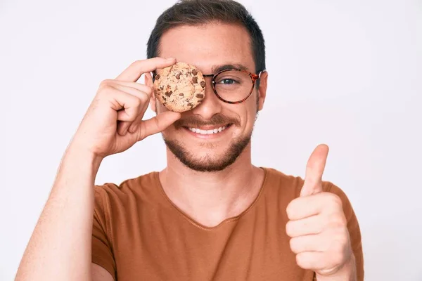 Jeune Bel Homme Tenant Cookie Souriant Heureux Positif Pouce Levé — Photo