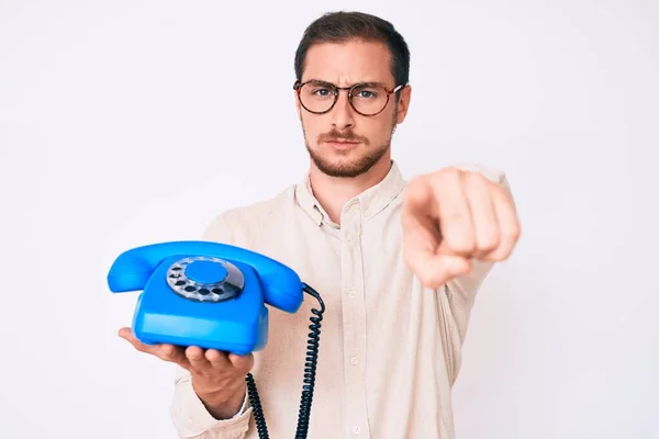 Jovem Homem Bonito Segurando Telefone Vintage Apontando Com Dedo Para — Fotografia de Stock