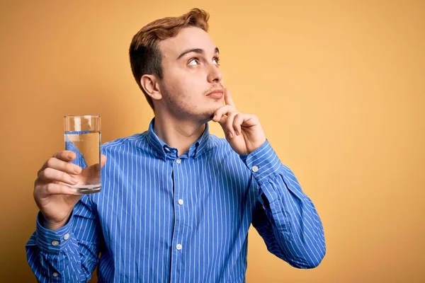 Ung Stilig Rödhårig Man Dricka Glas Vatten Över Isolerad Gul — Stockfoto