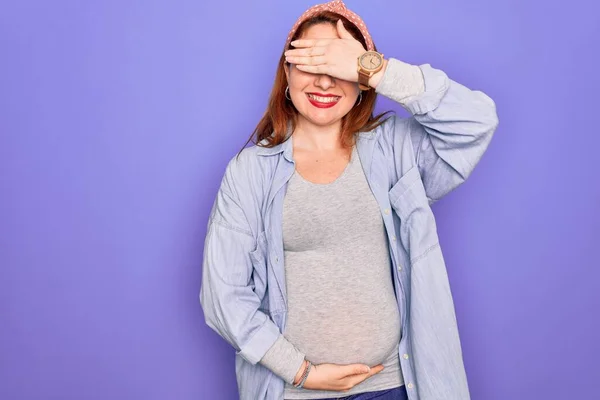 Stock image Young beautiful redhead pregnant woman expecting baby over isolated purple background smiling and laughing with hand on face covering eyes for surprise. Blind concept.