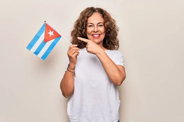 中年美しいです観光女性保持Cubanフラグ上の隔離されたホワイトバック笑顔幸せなポインティングとともに手と指 — ストック写真