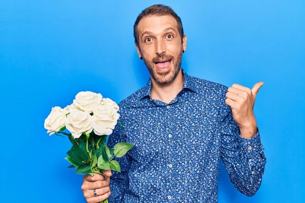 Ung Stilig Man Med Blommor Pekar Tummen Upp Till Sidan — Stockfoto