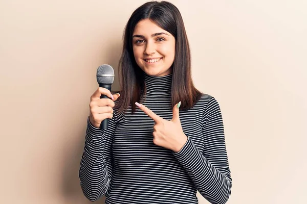 Jovem Menina Bonita Cantando Música Usando Microfone Sorrindo Feliz Apontando — Fotografia de Stock