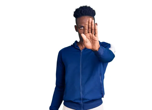 スポーツウェアを着た若いアフリカ系アメリカ人男性が手の手のひらで歌うのをやめる 顔に負の重大なジェスチャーで — ストック写真