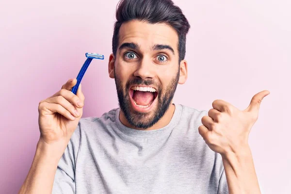 Joven Hombre Guapo Con Barba Sosteniendo Navaja Apuntando Pulgar Hacia — Foto de Stock