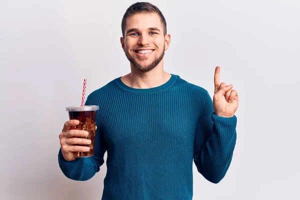 若いですハンサムな男飲むコーラのリフレッシュ飲料笑顔でアイデアや質問を指差す指で幸せな顔 ナンバーワン — ストック写真