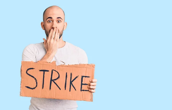 Young Handsome Man Holding Strike Banner Covering Mouth Hand Shocked — Stock Photo, Image