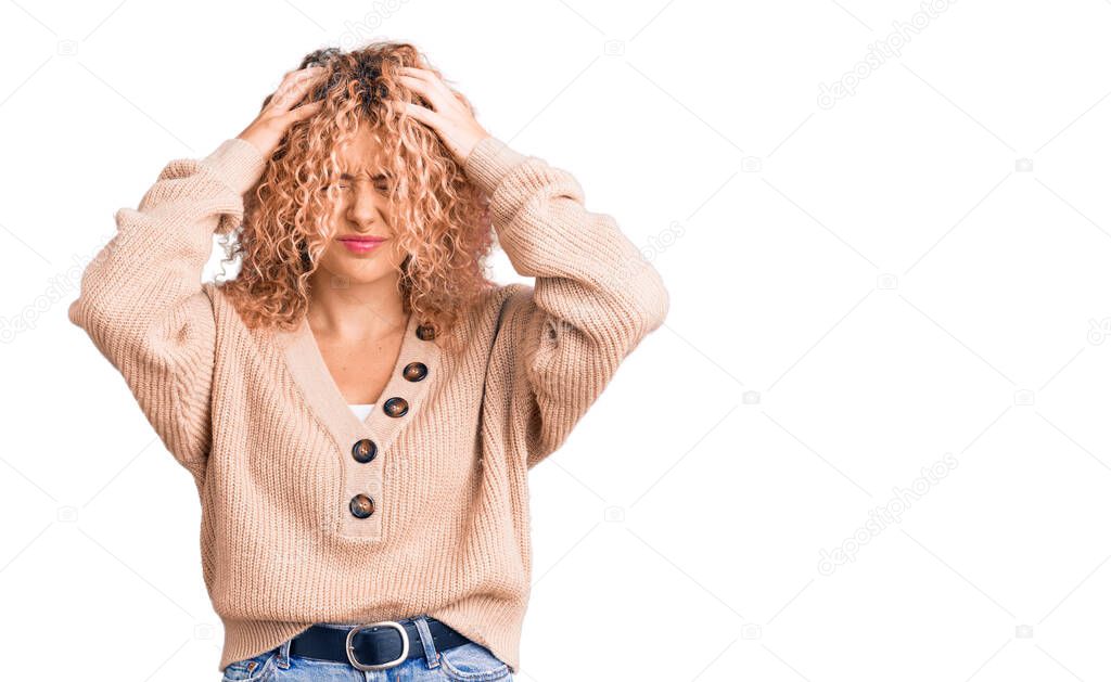 Young blonde woman with curly hair wearing casual winter jumper suffering from headache desperate and stressed because pain and migraine. hands on head. 
