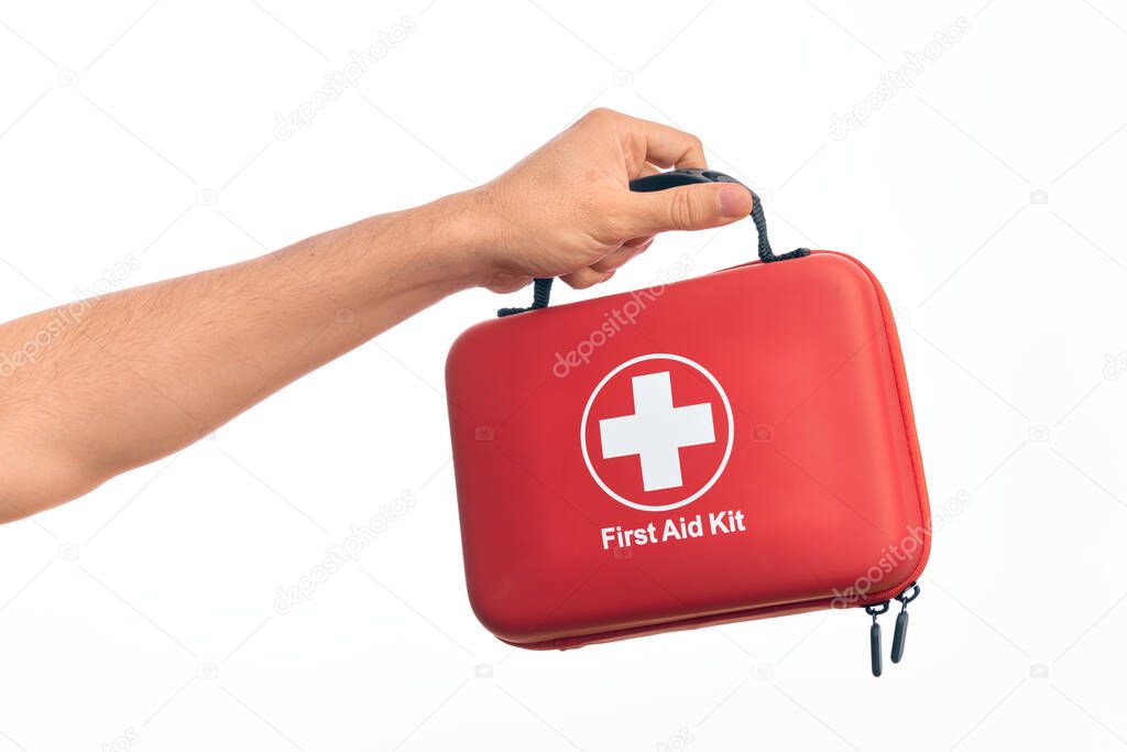 Hand of caucasian young man holding first aid kit over isolated white background