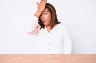 Orta yaşlı esmer, Latin kökenli, beyaz gömlekli bir kadın masada oturuyor. Yanlışlıkla el ele tutuşarak şaşırmış. Hatayı hatırla. Unuttum, kötü hafıza kavramı. 